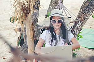 Lifestyle freelance woman using laptop working and relax on the beach.Â 